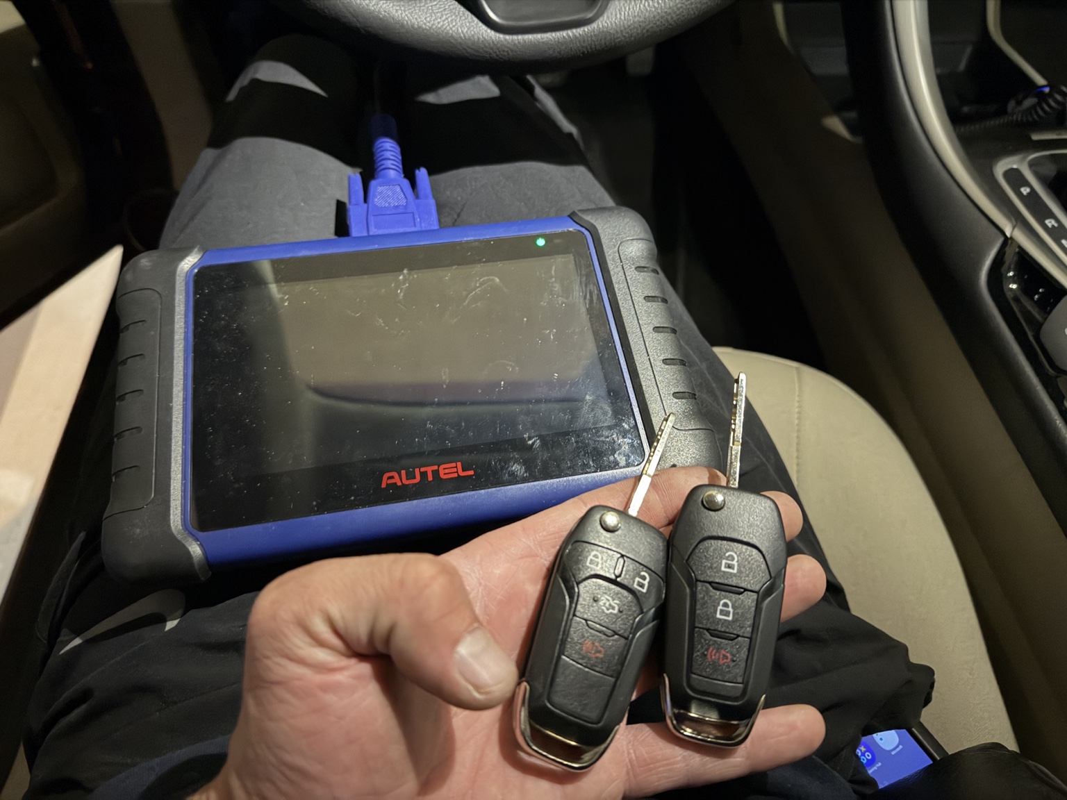 Два ключа рядом с оборудованием Autel в салоне Ford.